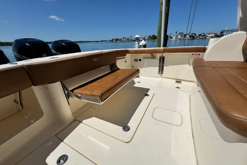 Slide: The Image of 2018 Scout 355 LXF boat interior with brown leather seating and Mercury engines. - 10