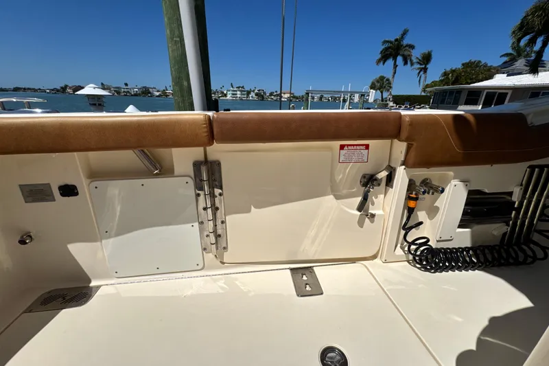 Slide: The Image of 2018 Scout 355 LXF boat interior with tan seating and ocean view. - 15