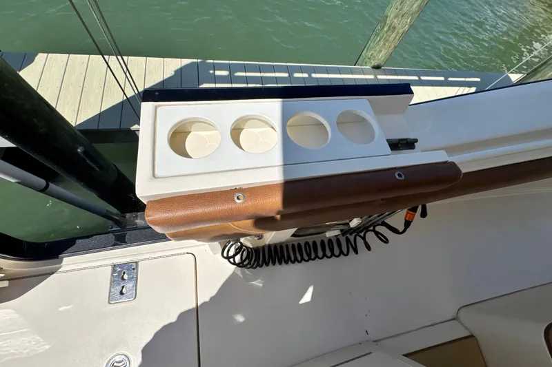 Slide: The Image of 2018 Scout 355 LXF boat interior with cup holders and dock view. - 17