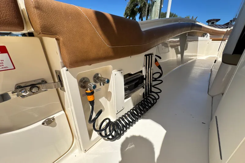 Slide: The Image of 2018 Scout 355 LXF boat deck with coiled hose and brown seating. - 19