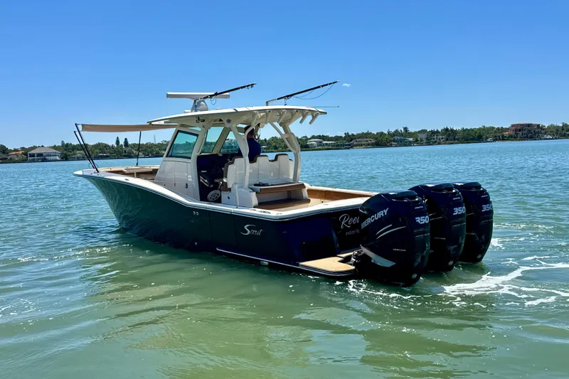 Slide: The Image of 2018 Scout 355 LXF boat with triple Mercury 350 engines on a sunny day. - 2