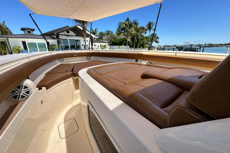 Slide: The Image of Luxurious 2018 Scout 355 LXF boat interior with brown leather seating under canopy. - 27