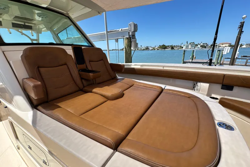 Slide: The Image of Luxurious seating on 2018 Scout 355 LXF boat, docked by serene waterfront. - 29
