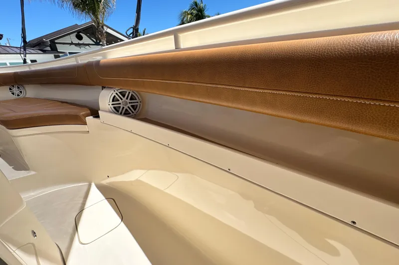 Slide: The Image of 2018 Scout 355 LXF boat interior with tan leather seating and built-in speakers. - 37