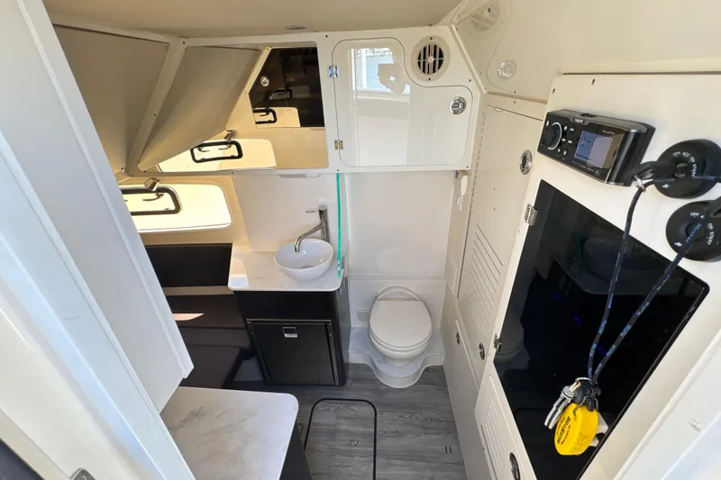 Slide: The Image of Interior of 2018 Scout 355 LXF boat featuring compact bathroom and modern amenities. - 38
