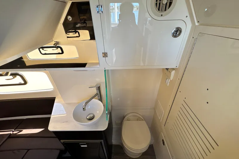 Slide: The Image of 2018 Scout 355 LXF boat interior with sink, toilet, and storage cabinets. - 39