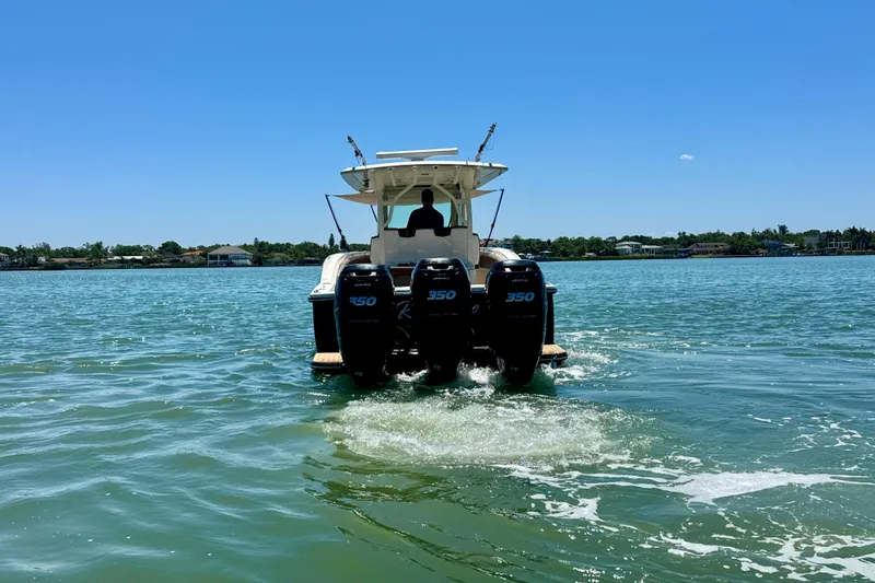 Slide: The Image of 2018 Scout 355 LXF boat cruising on a sunny day with triple 350 engines. - 4