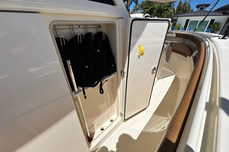 Slide: The Image of 2018 Scout 355 LXF boat storage compartment with open door and interior view. - 47