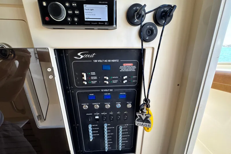 Slide: The Image of Control panel of a 2018 Scout 355 LXF boat with electrical switches and stereo system. - 53