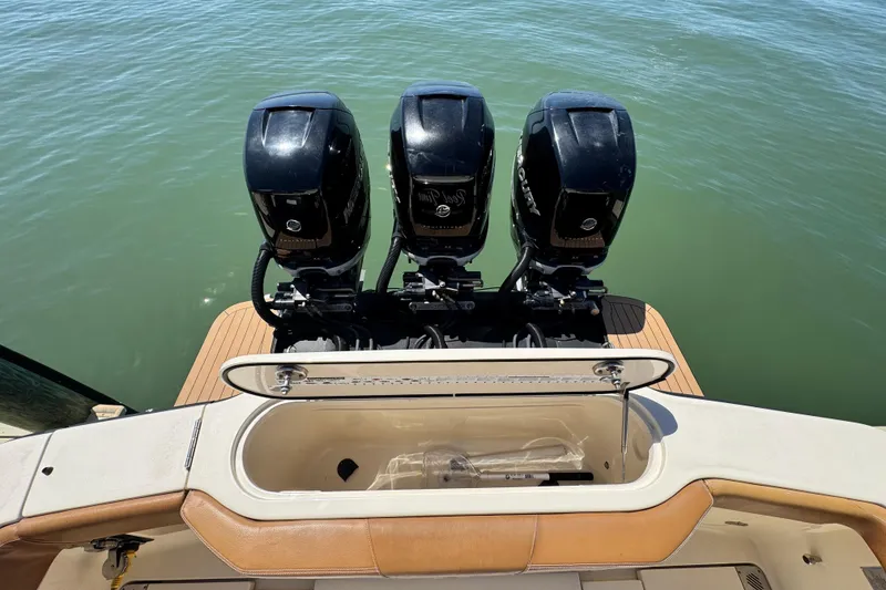 Slide: The Image of 2018 Scout 355 LXF boat with triple outboard engines on calm water. - 8