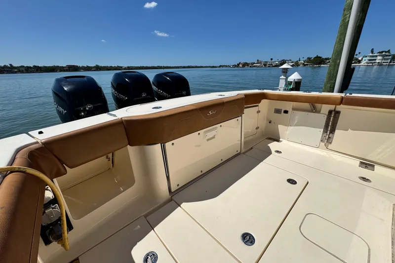 Slide: The Image of 2018 Scout 355 LXF boat deck with Mercury engines, docked by calm waters. - 9