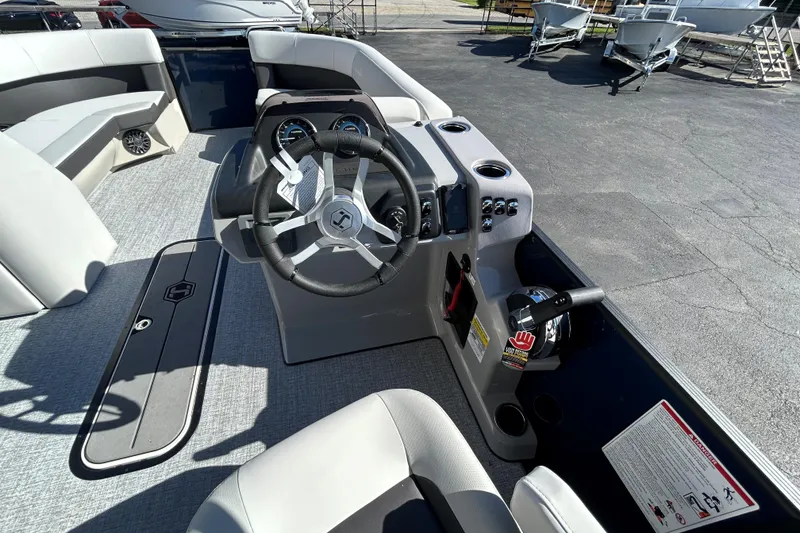 Slide: The Image of 2026 Harris Cruiser 230 CWDH boat interior with steering wheel and seating area. - 12