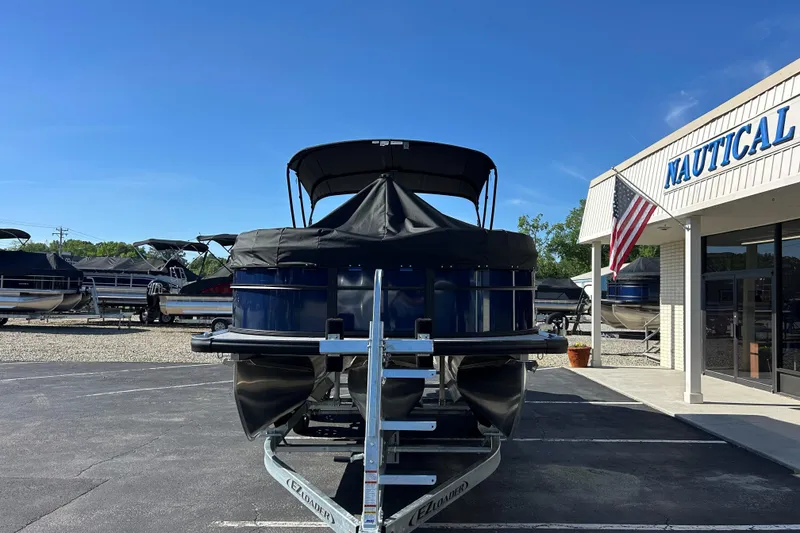 Slide: The Image of 2026 Harris Cruiser 230 CWDH pontoon boat at a dealership with American flag. - 21