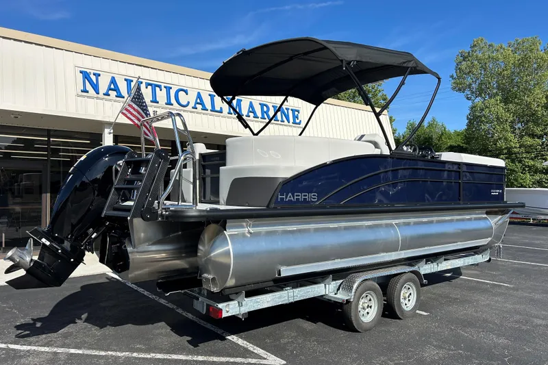 Slide: The Image of 2026 Harris Cruiser 230 CWDH pontoon boat on trailer outside Nautical Marine store. - 6