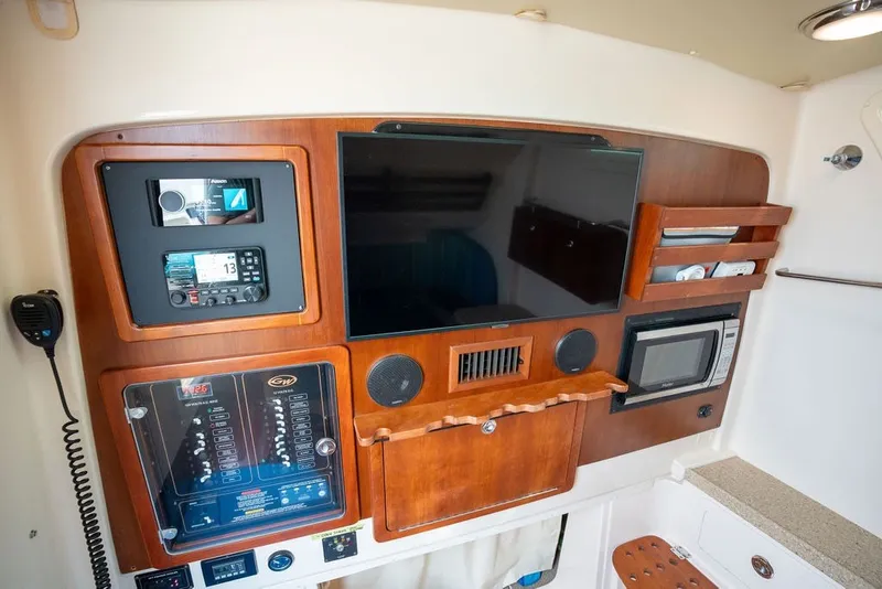 Slide: The Image of 2014 Grady-White Canyon 376 cabin interior with control panel, microwave, and storage. - 57