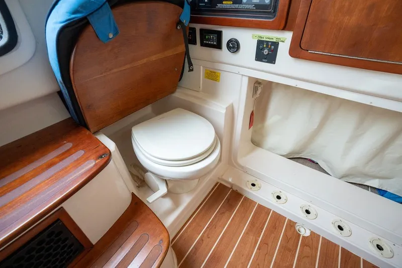Slide: The Image of 2014 Grady-White Canyon 376 boat interior with wooden flooring and compact marine toilet. - 64