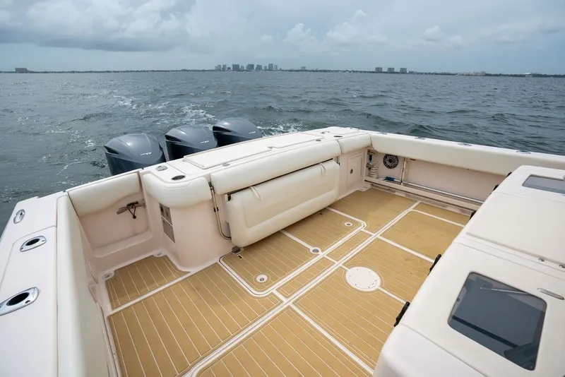 Slide: The Image of 2014 Grady-White Canyon 376 boat deck with triple outboard motors on open water. - 34