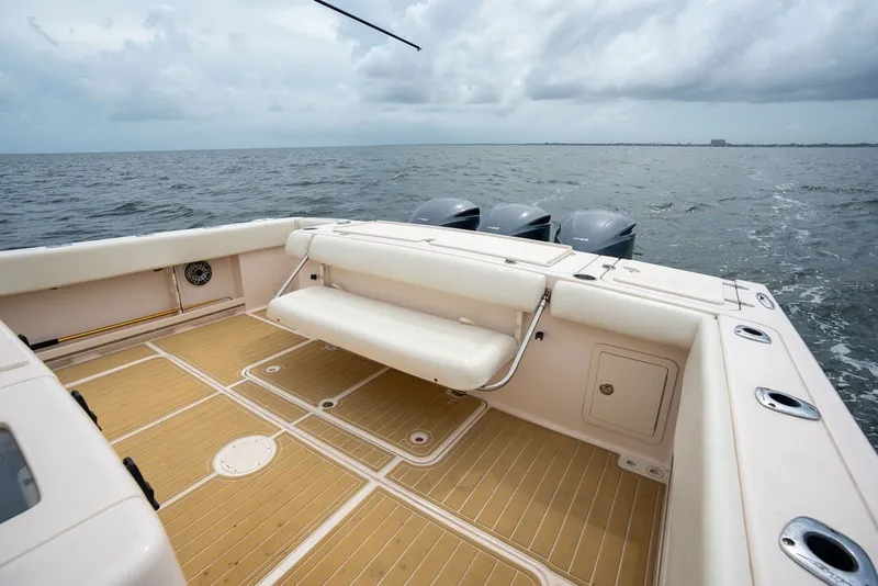 Slide: The Image of 2014 Grady-White Canyon 376 boat deck with seating, ocean view, and triple outboard motors. - 24