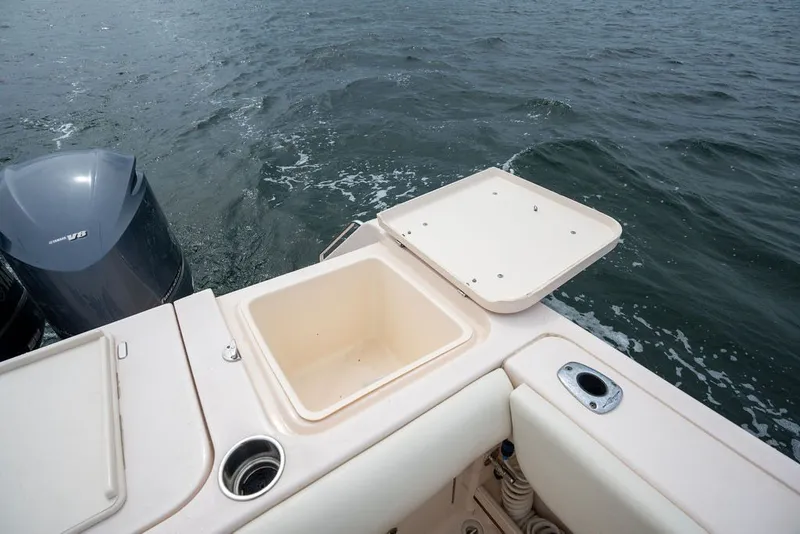 Slide: The Image of 2014 Grady-White Canyon 376 boat with open storage compartment and V8 engine on water. - 25