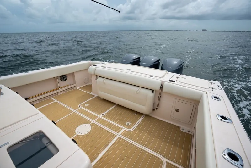 Slide: The Image of 2014 Grady-White Canyon 376 boat deck with triple outboard motors on open water. - 33