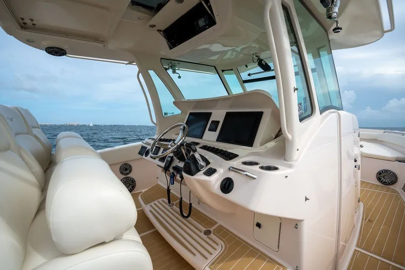 Slide: The Image of 2014 Grady-White Canyon 376 boat interior with steering wheel and navigation screens. - 43