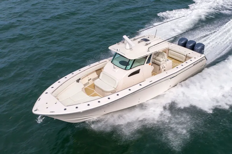 Slide: The Image of 2014 Grady-White Canyon 376 boat cruising on open water, showcasing sleek design and powerful engines. - 12