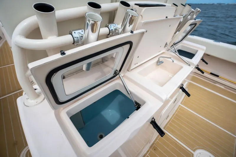 Slide: The Image of 2014 Grady-White Canyon 376 boat with open storage compartments and rod holders on deck. - 32