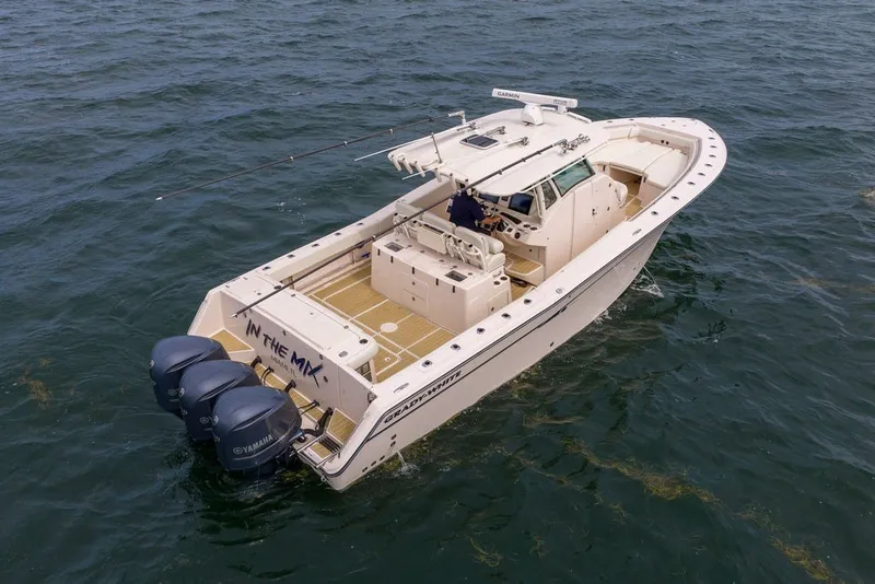 Slide: The Image of 2014 Grady-White Canyon 376 boat on open water, featuring triple Yamaha engines. - 5