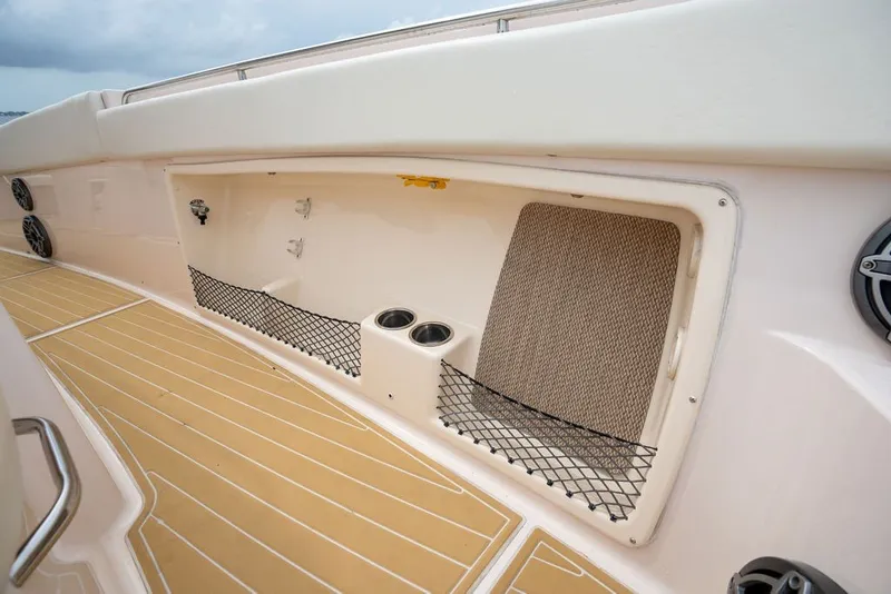 Slide: The Image of 2014 Grady-White Canyon 376 boat interior storage compartment with netting and cup holders. - 21