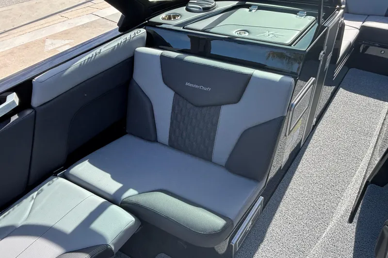 Slide: The Image of 2026 MasterCraft XT24 boat interior with gray seating and storage compartments. - 6