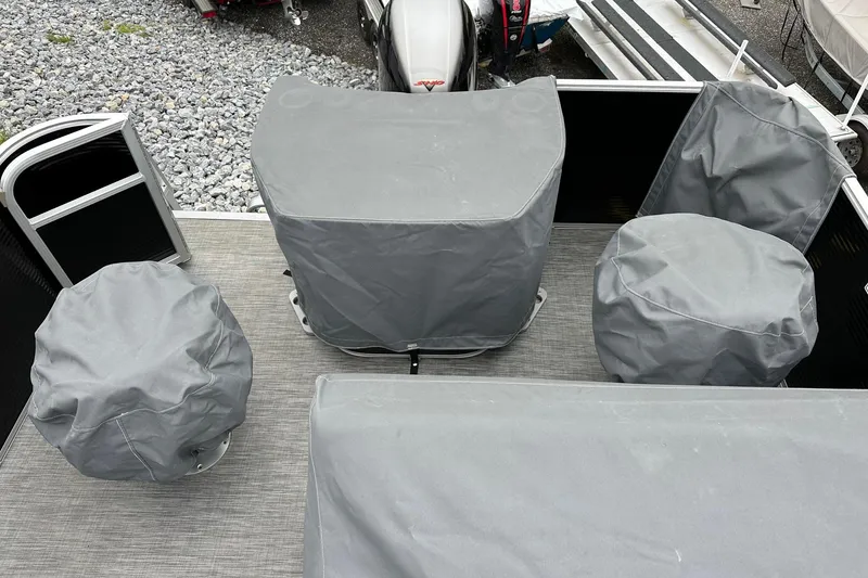 Slide: The Image of 2020 Bennington 20 SSNPX pontoon boat interior with covered seats and motor. - 20