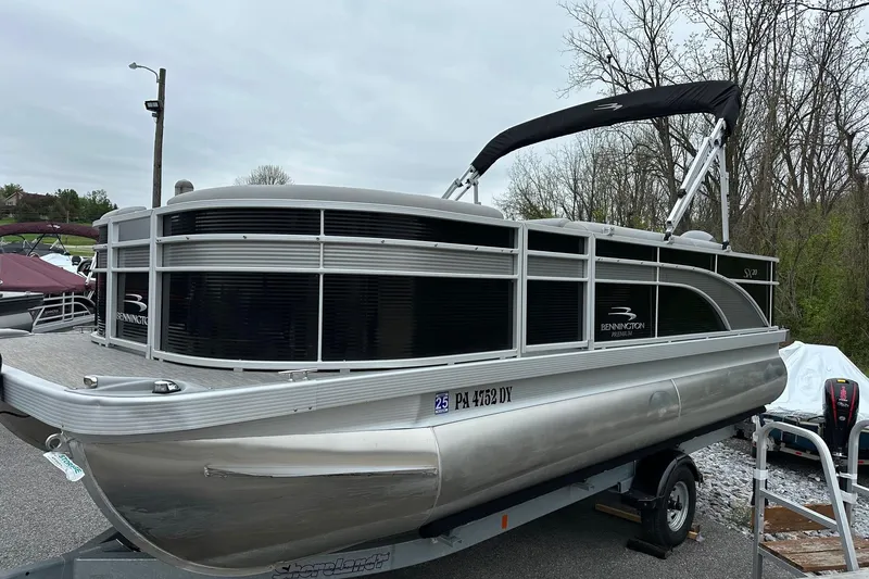 Slide: The Image of 2020 Bennington 20 SSNPX pontoon boat with VMAX 90 SHO engine, parked outdoors. - 3