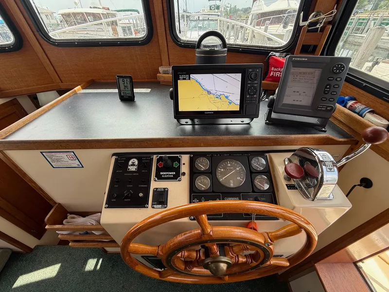 Slide: The Image of 1998 Nordic Tug Trawler helm with navigation equipment and wooden steering wheel. - 16