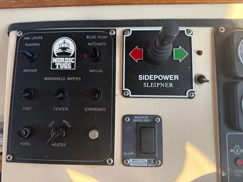 Slide: The Image of Control panel of a 1998 Nordic Tug Trawler with various switches and joystick. - 9