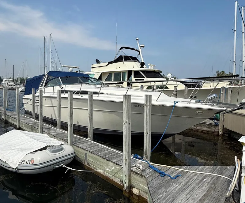 Slide: The Image of 1989 Sea Ray 460 Express Cruiser docked at marina, clear sky background. - 2