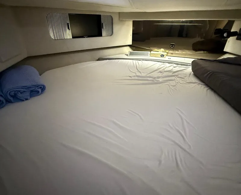 Slide: The Image of Cozy cabin interior of 1989 Sea Ray 460 Express Cruiser with bed and rolled towels. - 21