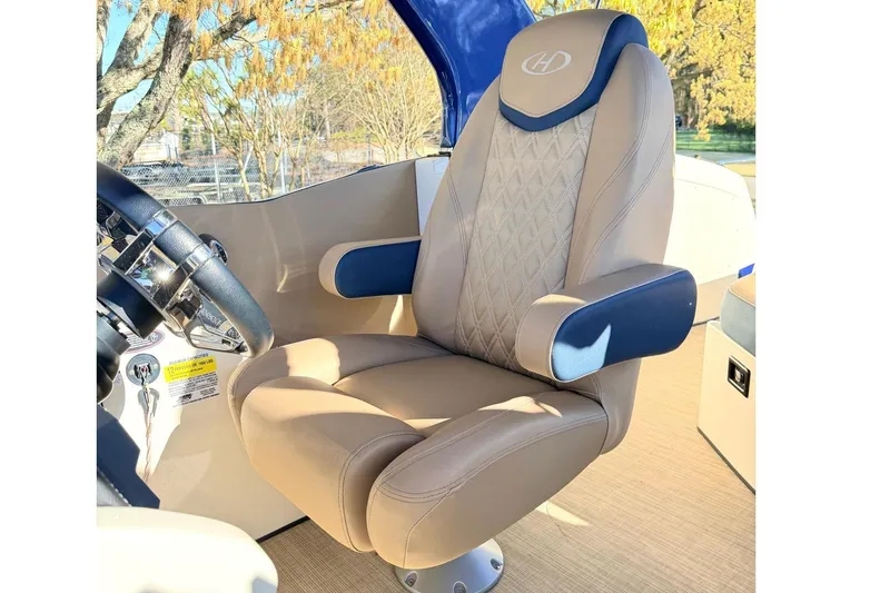 Slide: The Image of Captain's chair on 2021 Harris Crowne SL 250 boat, featuring tan upholstery and blue accents. - 15