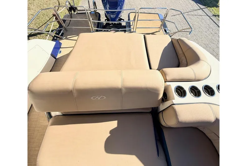 Slide: The Image of 2021 Harris Crowne SL 250 boat with tan seating and blue motor, parked outdoors. - 16