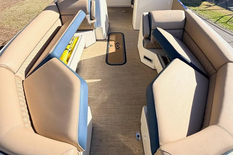 Slide: The Image of 2021 Harris Crowne SL 250 pontoon boat interior with tan seating and open deck. - 4