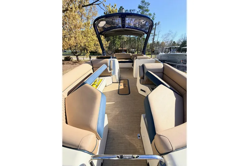 Slide: The Image of 2021 Harris Crowne SL 250 pontoon boat interior with beige seating and open deck. - 5