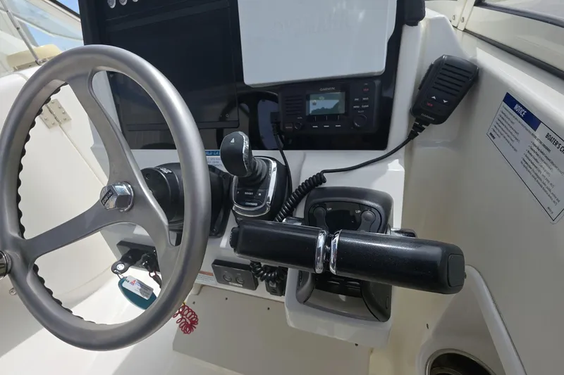 Slide: The Image of 2021 World Cat 296 DC boat helm with steering wheel and controls. - 10