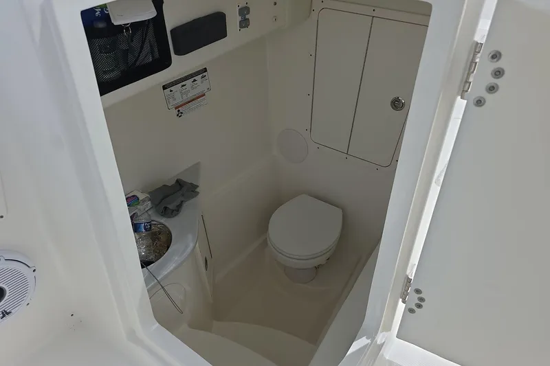 Slide: The Image of Interior view of 2021 World Cat 296 DC boat bathroom with toilet and storage. - 12