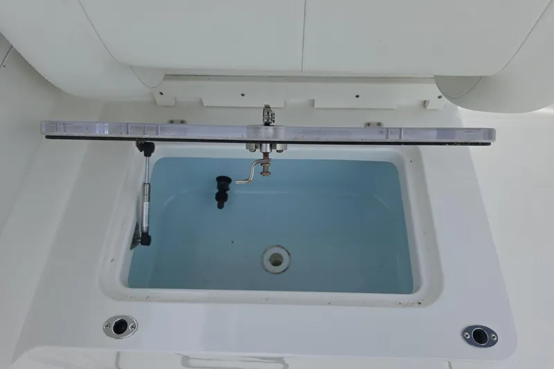 Slide: The Image of Livewell compartment on a 2021 World Cat 296 DC boat, featuring a lid and drain. - 14