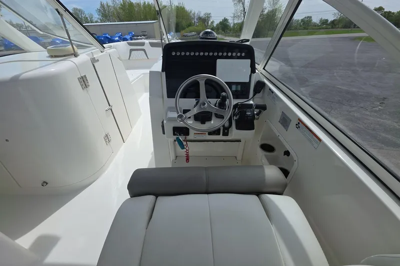 Slide: The Image of 2021 World Cat 296 DC boat cockpit with steering wheel and control panel. - 9