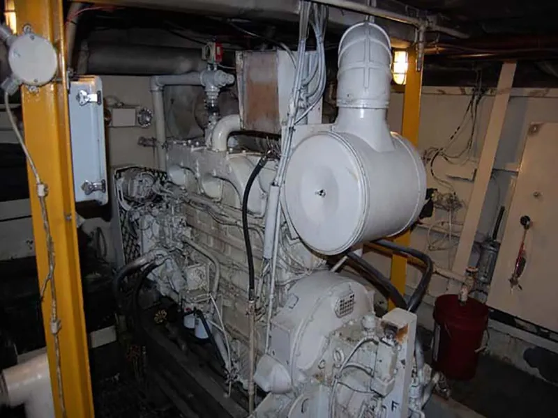Slide: The Image of Engine room of 1985 Custom Serodino Dinner Boat, featuring large machinery and pipes. - 31