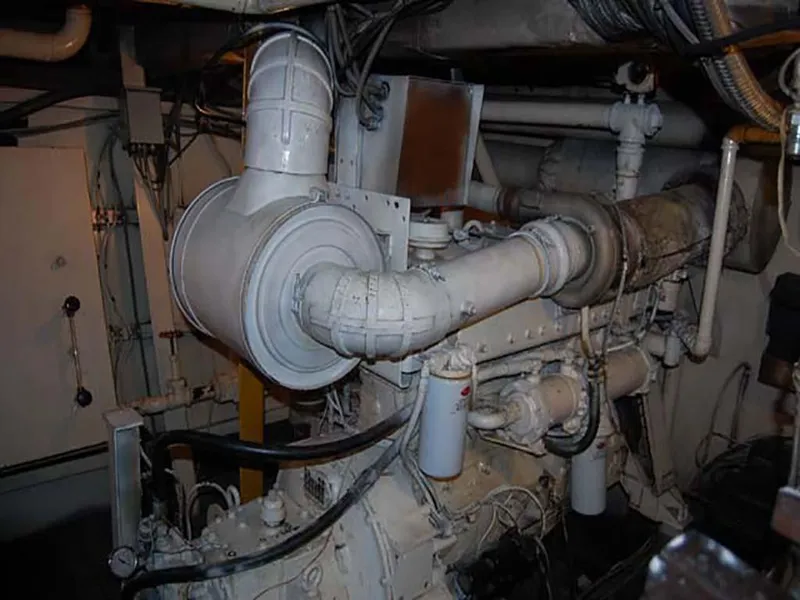 Slide: The Image of Engine room of a 1985 Custom Serodino Dinner Boat, showcasing complex machinery and piping. - 32