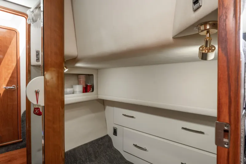 Slide: The Image of Interior cabin of 2003 Sea Ray 480 Motor Yacht with storage and wooden accents. - 15