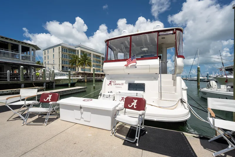 Slide: The Image of 2003 Sea Ray 480 Motor Yacht docked at marina with chairs and American flag. - 2