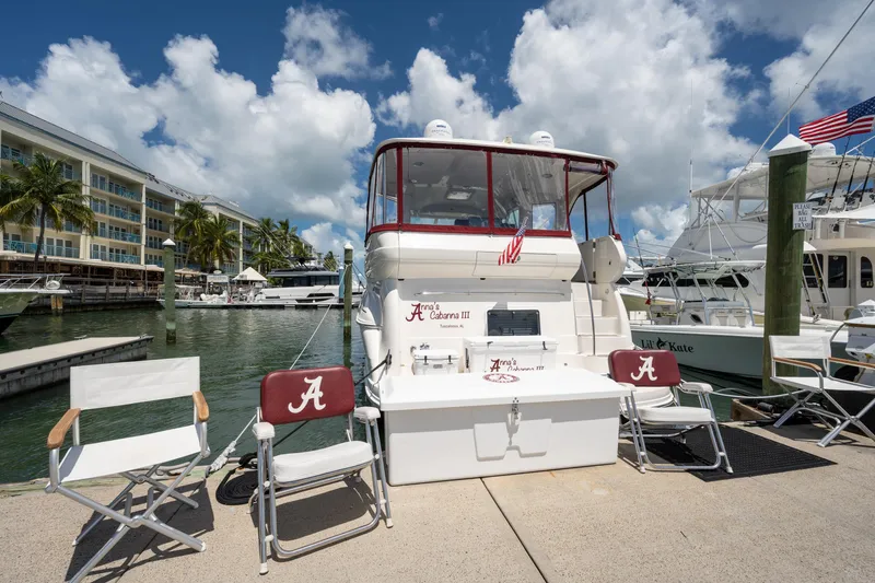 Slide: The Image of 2003 Sea Ray 480 Motor Yacht docked at marina with chairs and American flag. - 4