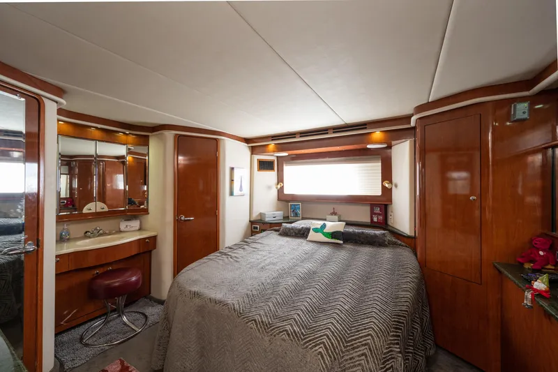 Slide: The Image of Luxurious bedroom interior of 2003 Sea Ray 480 Motor Yacht with wood accents and cozy bedding. - 42